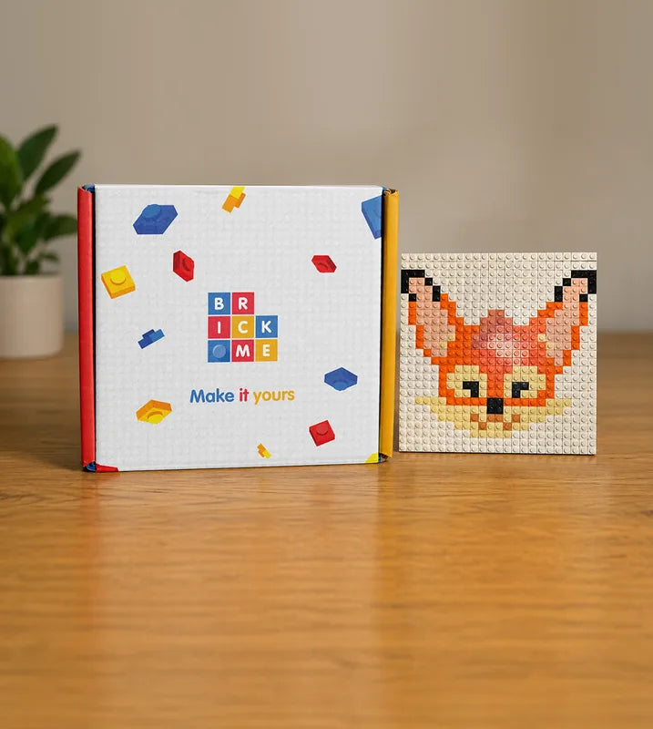 A logo mosaic kit box beside the finished brick artwork it builds