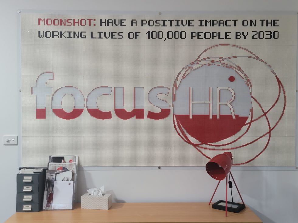 A company logo mosaic on an office wall, left part-built to track milestones