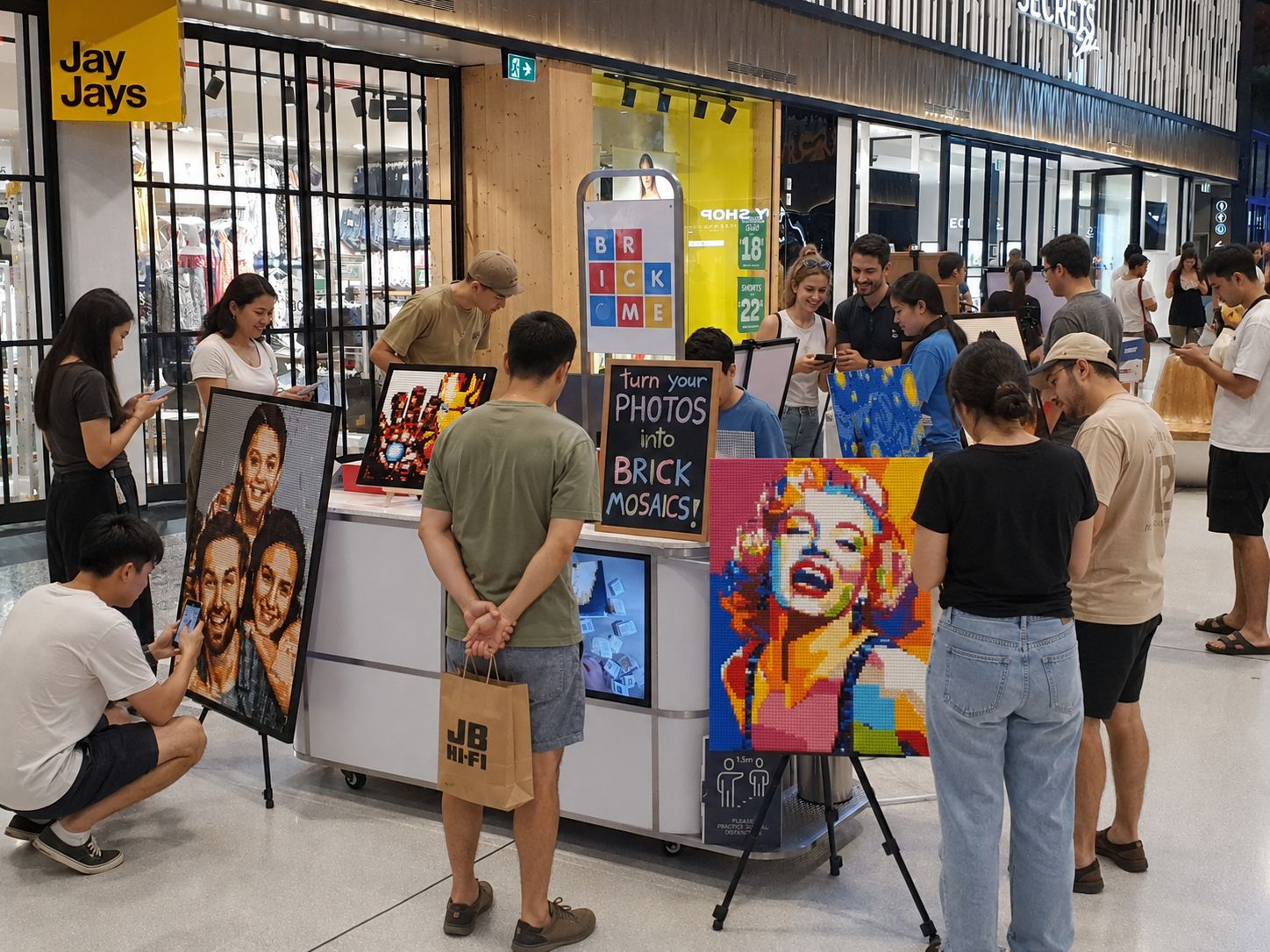 Crowd of shoppers around a Brick Me kiosk